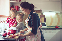 Mother with her 5 years old kids cooking holiday pie in the kitchen to Mothers day, casual lifestyle photo series in real life interior